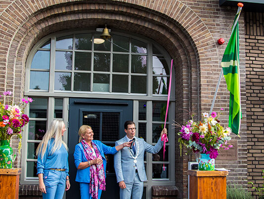 Burgemeester Van Oostrum luidt de bel om Huize Willibrordus officieel te openen.