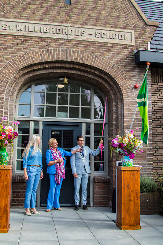 Burgemeester Van Oostrum luidt de bel om Huize Willibrordus officieel te openen. 