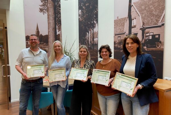 Vijf locatiemanagers staan op een rij en krijgen green care certificaat uitgereikt.